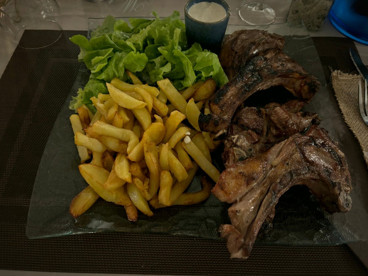Côtes d'agneau grillées au feu de bois avec frites et salade